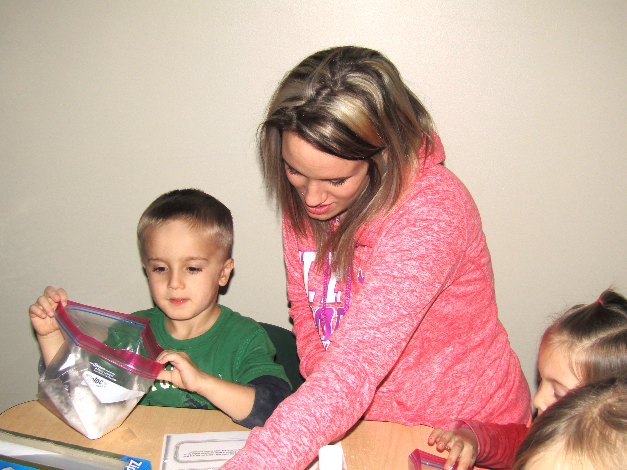 a mother and son working together to create bags for an activity called Magic Touch 