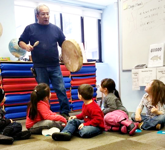 cultural consultant teaching an Ojibwe song to the children.