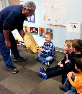 cultural consultant shows a drum to the children.