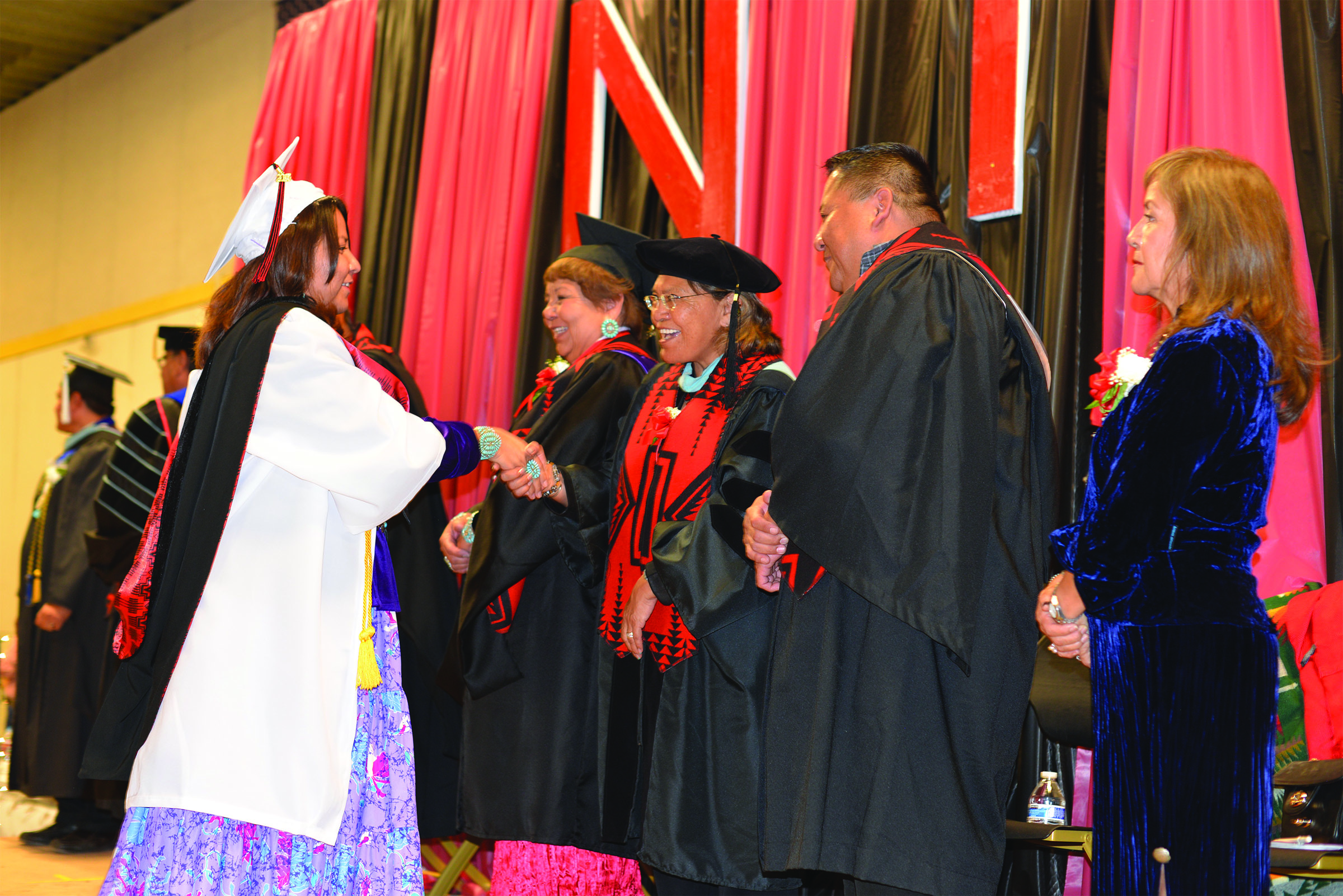 Graduate Ramara Begay shakes hands with NTU’s Board of Regents and Navajo Nation Poet Laureate Dr. Laura Tohe at NTU’s fall commencement. Begay was one of six students to receive a Bachelor of Science degree in Early Childhood Multicultural Education.
