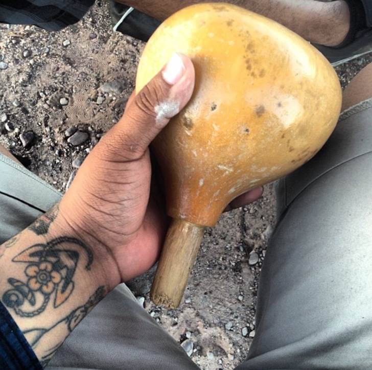 Holding a gourd rattle