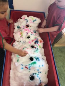 Children discover the changes in color on the snow that was brought into their classroom on a cold winter day.