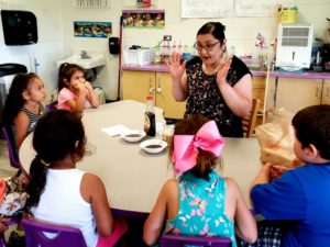 Maria Defoe, pre-service teacher in the Anishinaabe Seasonal Science course, teaching a lesson to children on the science of sugar bush.
