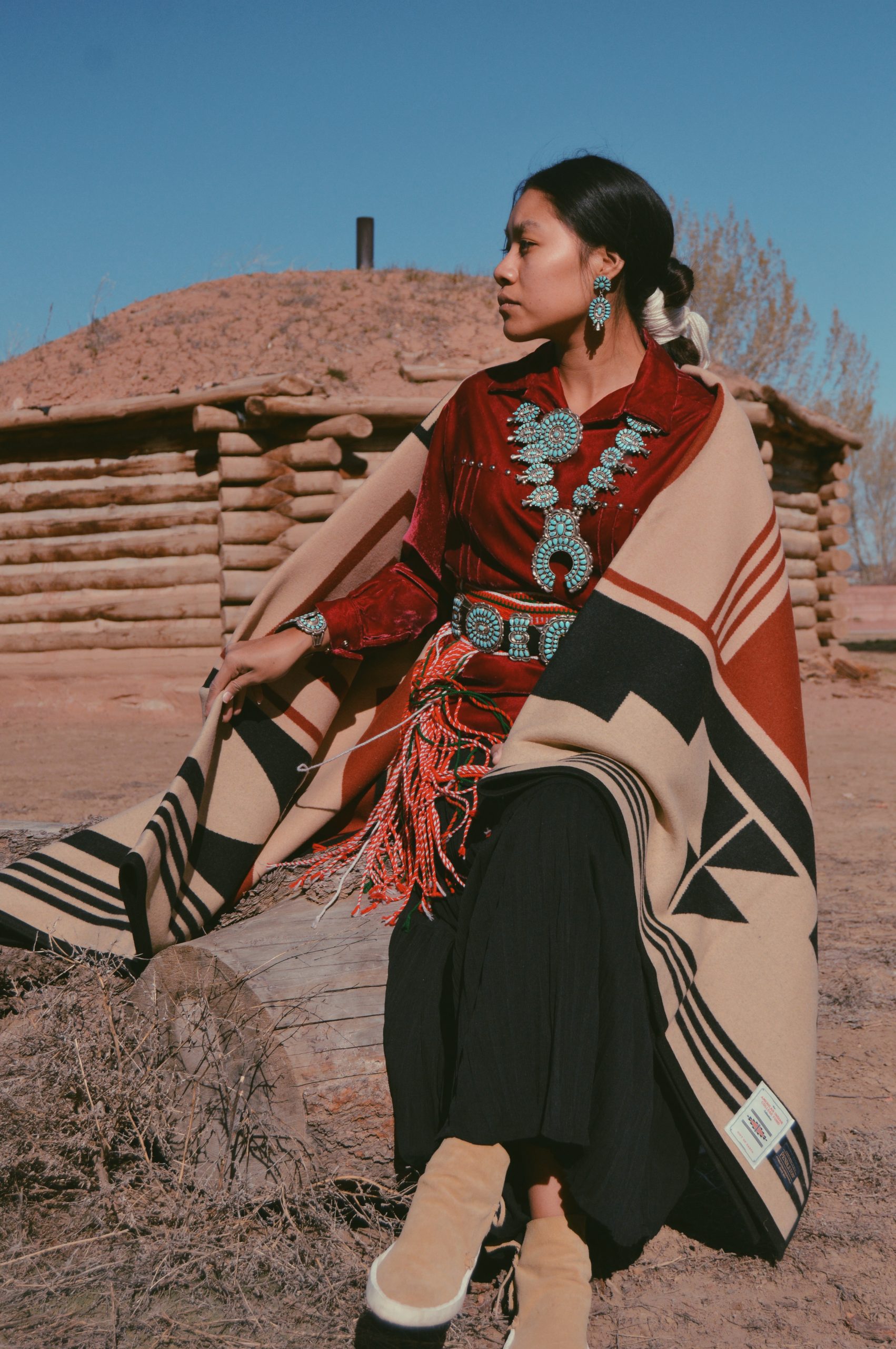 Shondina Lee models the new blanket outside of a Navajo Hogan.