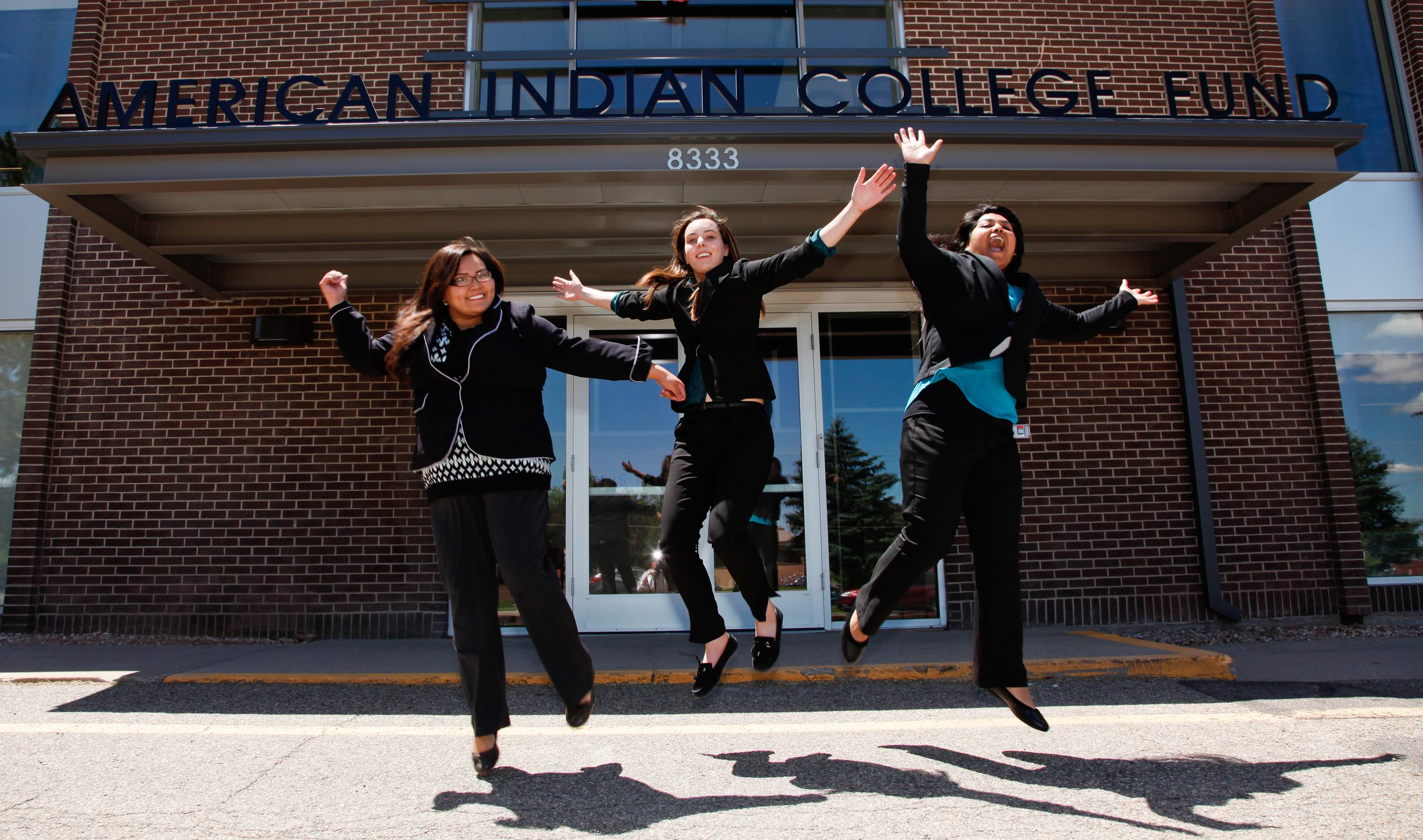 The Interns take a jumping pose in front of the American Indian College Fund