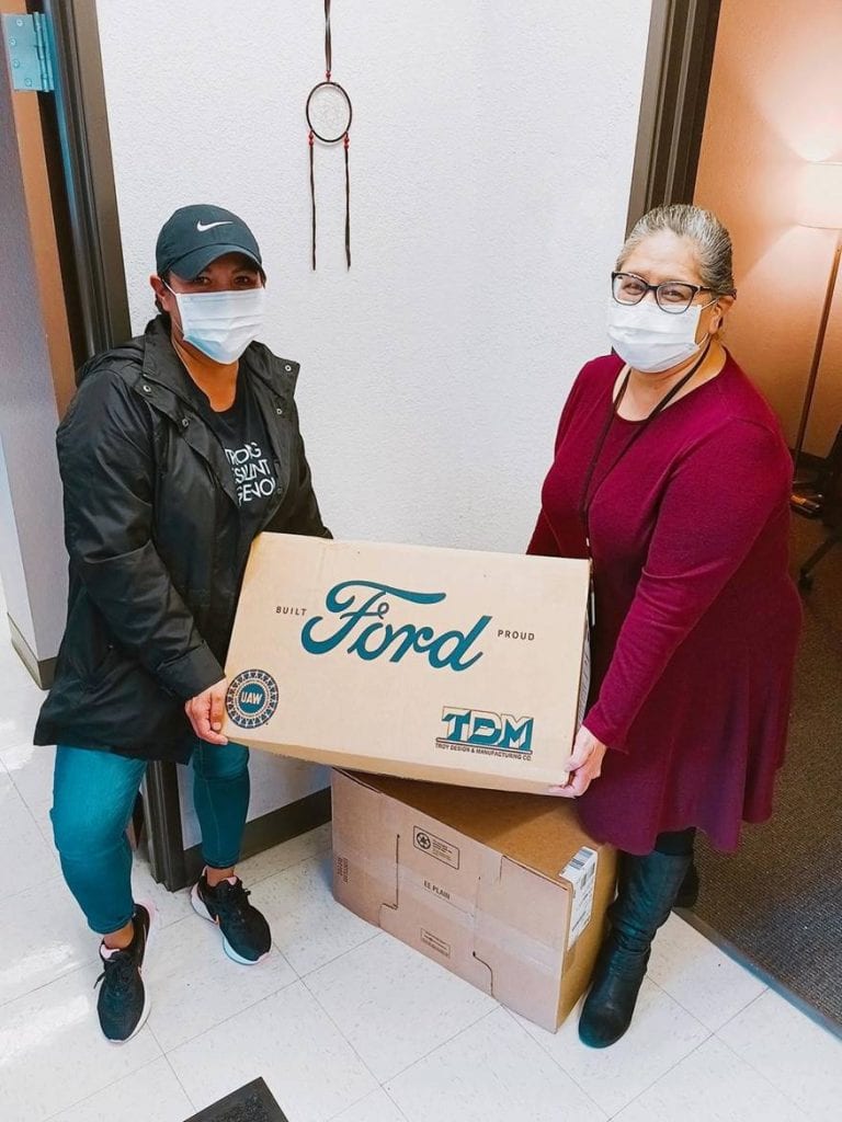 Adrianne Maddux, Denver Indian Health and Family Services (DIHFS) Executive Director (right) is assisted by Crystal Hedgepeth (left), an American Indian College Fund staff member and DIHFS board member, with a delivery of personal protective equipment.