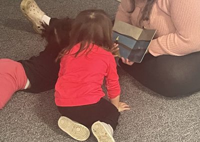 Early Childhood student shares her book with a child a KBIC Preprimary program.