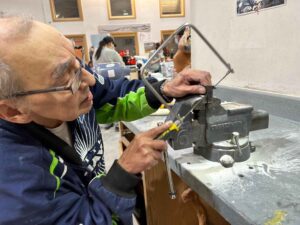 Ira showing how to cut using a saw.