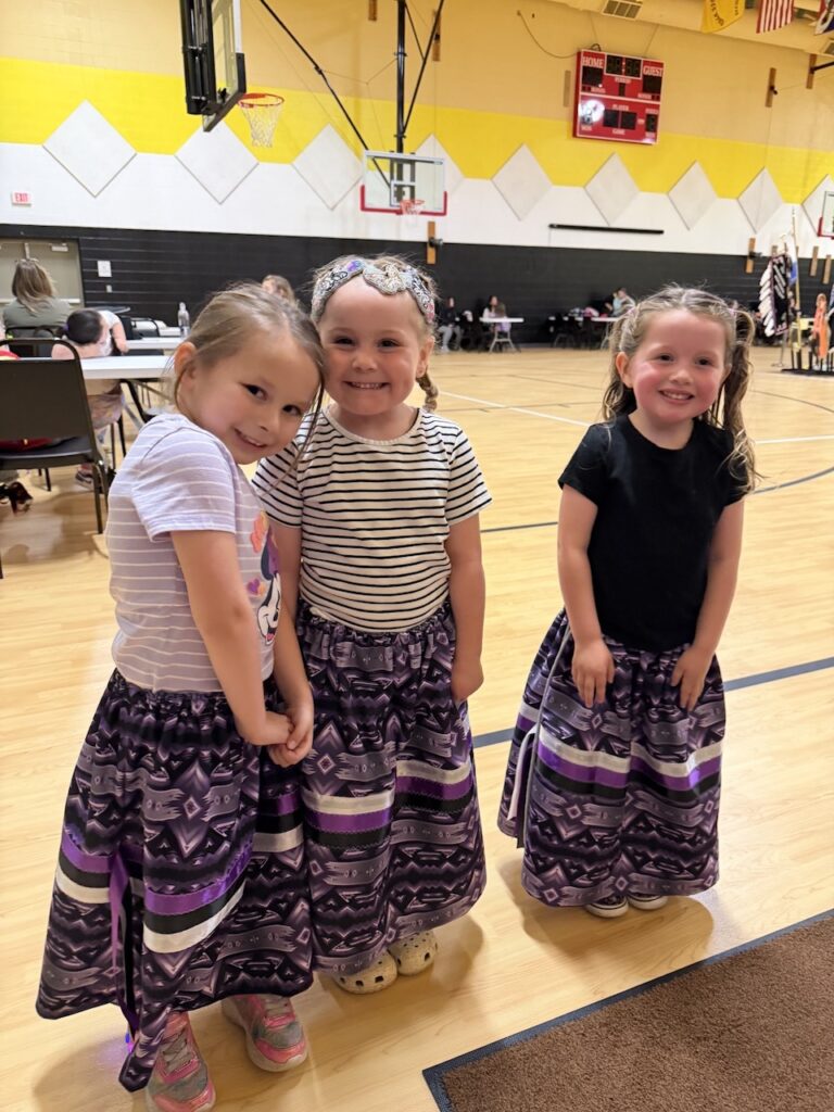 Three Preprimary children in their regalia at the Children’s Pow Wow at the KBOCC Childrens Pow Wow 2026